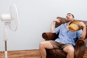 man-feeling-hot-in-front-of-fan